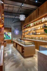 a vibrant interior of a modern la cannabis dispensary, showcasing sleek displays filled with colorful cannabis products, bathed in warm, inviting lighting that creates a welcoming atmosphere for shoppers.